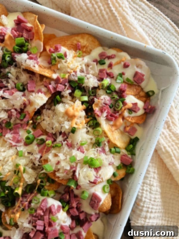 Loaded Reuben Nachos 2 Reuben Nachos loaded on potato chips with Swiss cheese sauce, corned beef, kraut, and Thousand Island dressing