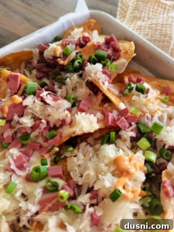 Loaded Reuben Nachos 15 A close-up shot of a serving of Reuben Nachos with perfect melted cheese and toppings