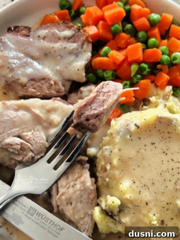 Cooked pork roast sliced, revealing tender, juicy meat with a golden-brown crust, ready to be drenched in rich gravy.