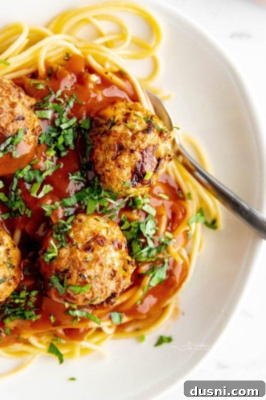 Crispy Air Fryer Turkey Meatballs 10 Air fried turkey meatballs on a plate with pasta and sauce.