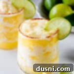 Close up of Frozen Pineapple Margarita garnished with a slice of lime.