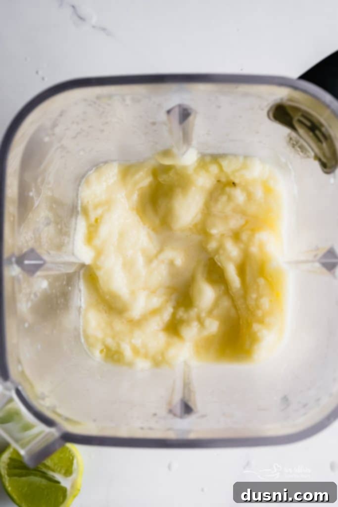 Blender in action, smoothly blending the pineapple margarita ingredients into a frosty mixture.