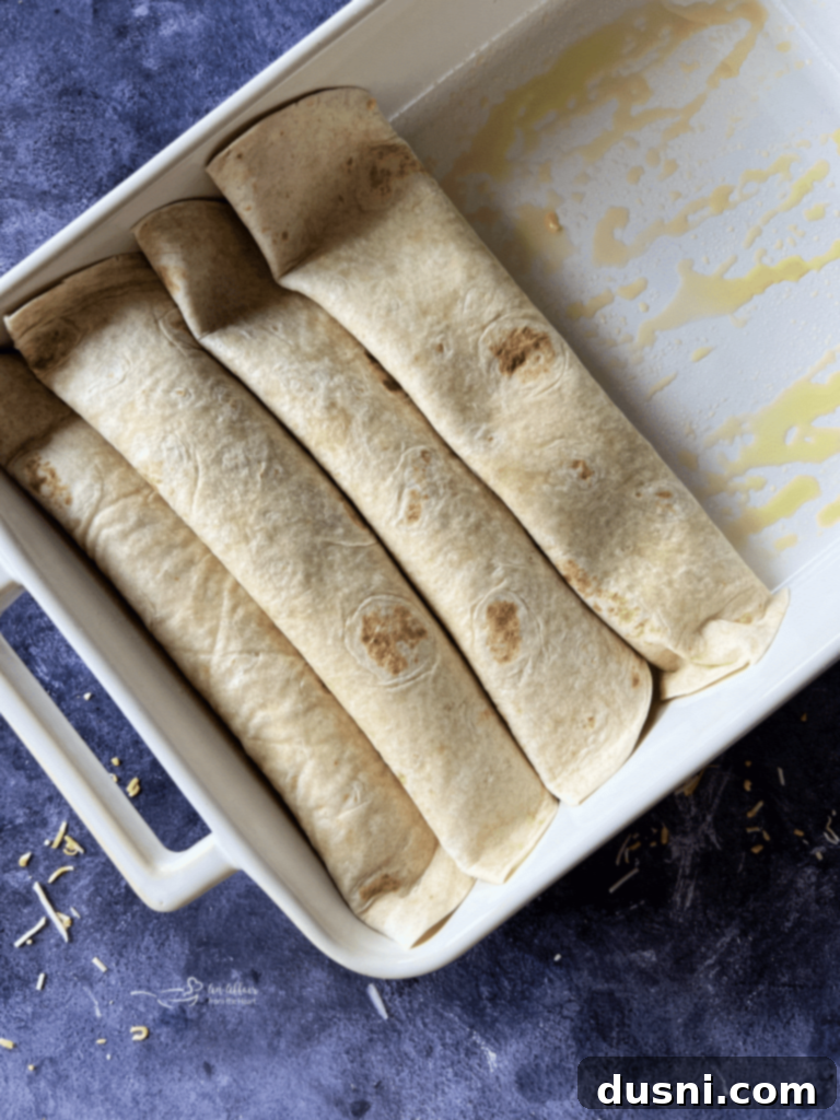 Tortillas filled with bean mixture, cheese, and onion, ready to be rolled