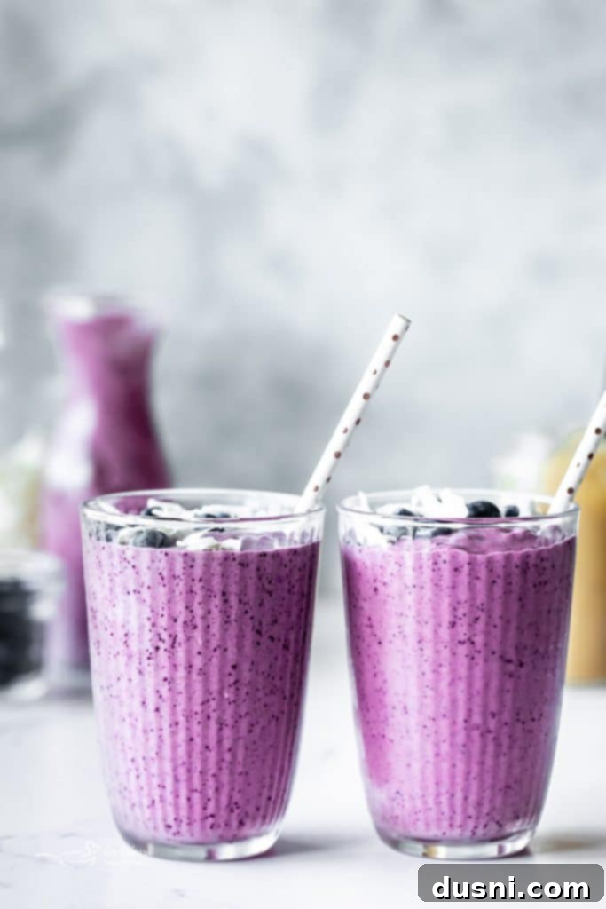 Vibrant Blueberry Pineapple Refresher 8 Overhead shot of a Blueberry Pineapple Smoothie in a glass, with a spoon of flax seeds and fresh fruit.