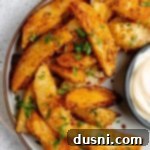 Roasted parmesan garlic potato wedges on a serving plate.