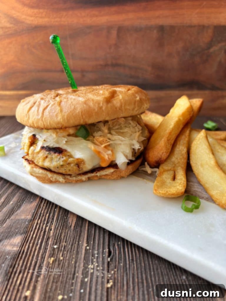 A beautifully assembled Turkey Reuben Burger with melted Swiss cheese and sauerkraut.