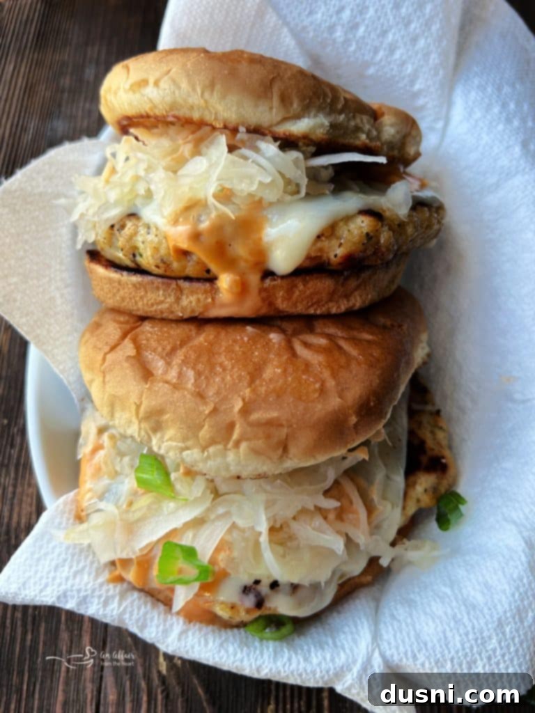 A side view of a gourmet Turkey Reuben Burger, showing all layers.