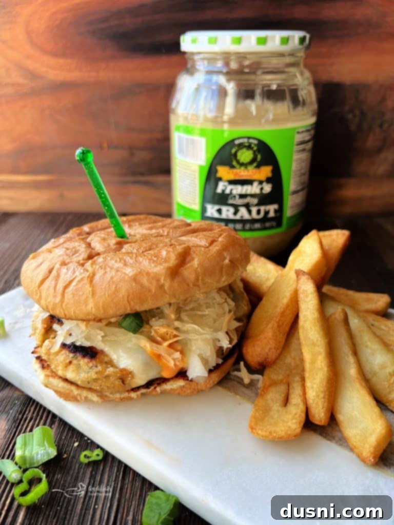 Two gourmet Turkey Reuben Burgers served with a side of french fries.