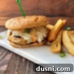 A Turkey Reuben burger and french fires on a white marble slab.