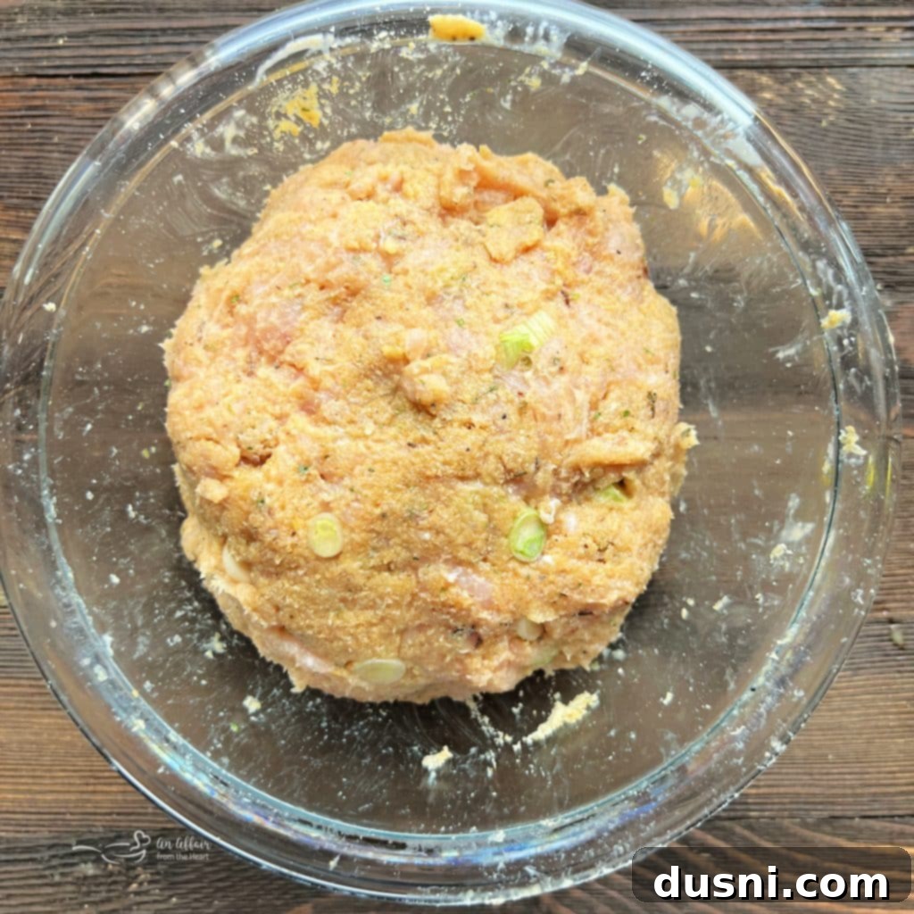 Close-up of the mixed turkey burger ingredients in a bowl, ready for forming patties.