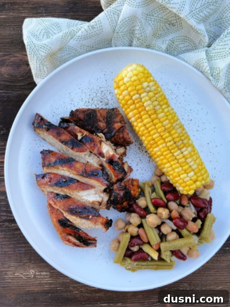 Sweet and smoky grilled chicken with a side of bean salad and corn.
