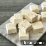 Yuletide Eggnog Bliss 11 Eggnog Fudge stacked on a marble cutting board