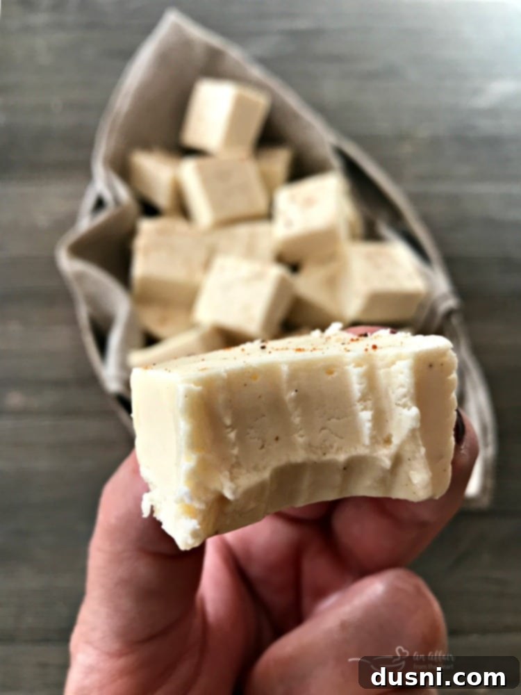 Yuletide Eggnog Bliss 5 Individual pieces of white chocolate eggnog fudge dusted with nutmeg, ready to be enjoyed as a festive dessert.