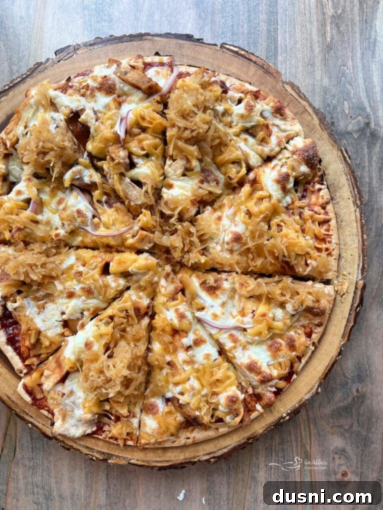 Close-up of a generous slice of BBQ Chicken Pizza with Kraut, highlighting the unique topping.