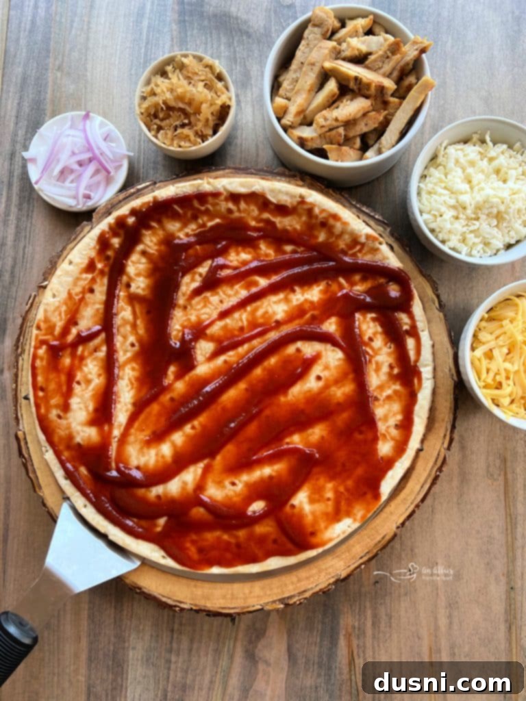 Step 1: Spreading barbecue sauce evenly over the pizza crust.