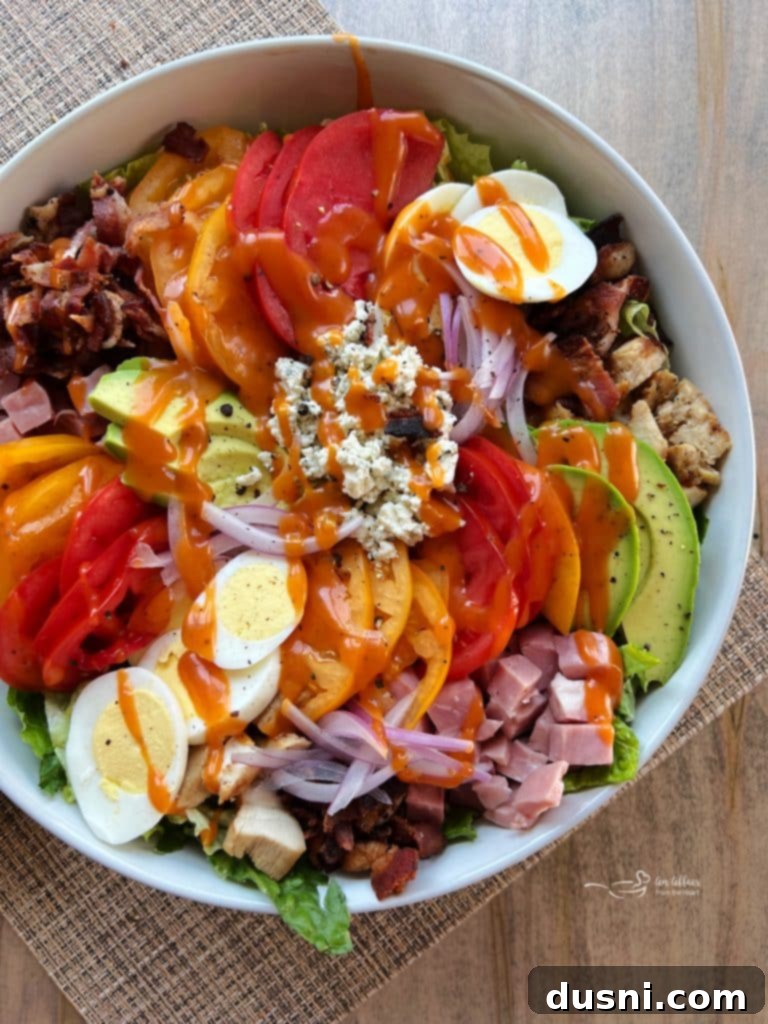 Summer's Crisp Cobb 2 A vibrant Summertime Cobb Salad with all ingredients neatly arranged in rows, topped with Dorothy Lynch dressing.