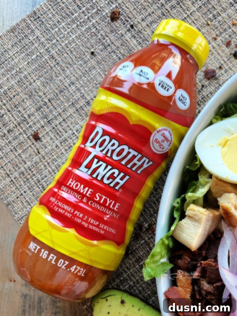 Summer's Crisp Cobb 3 A beautifully presented Dorothy Lynch Cobb Salad in a white bowl, showcasing vibrant ingredients.