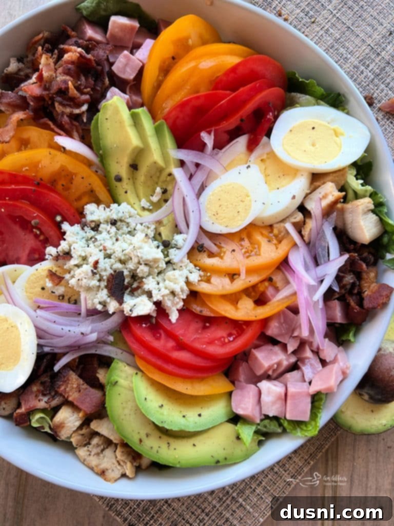 Summer's Crisp Cobb 5 Assembling Dorothy Lynch Summertime Cobb Salad by arranging ingredients in a large bowl.