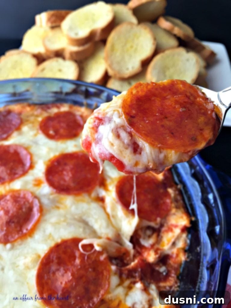 Irresistible Dips for Every Occasion 9 A spoonful of warm, cheesy Pizza Dip, featuring melted cheese and pepperoni.