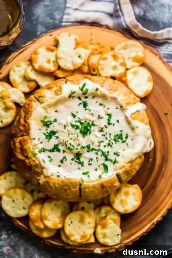 Irresistible Dips for Every Occasion 15 A creamy Beer Cheese Dip served in a bread bowl, surrounded by soft pretzel bites.