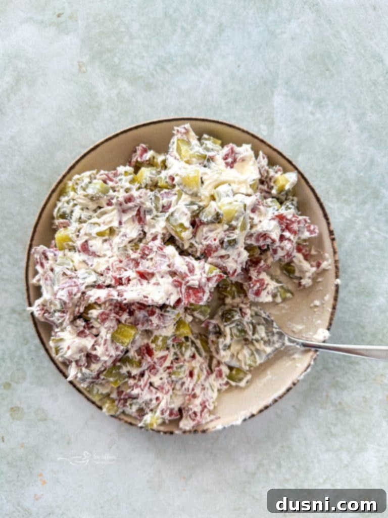 Irresistible Dips for Every Occasion 4 A spoon in a bowl of creamy Dill Pickle Dip, ready to be enjoyed with chips or veggies.