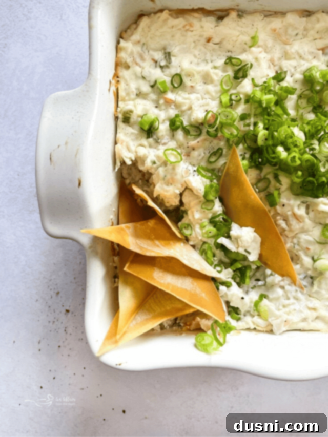 Irresistible Dips for Every Occasion 7 A bowl of creamy Crab Rangoon Dip with crispy wonton chips for dipping.