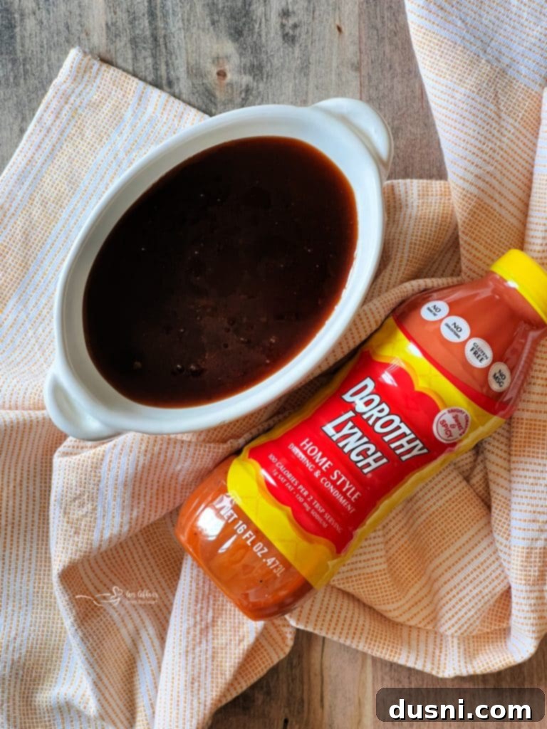 A tray of bacon-wrapped water chestnuts baking in the oven, with some already glazed.