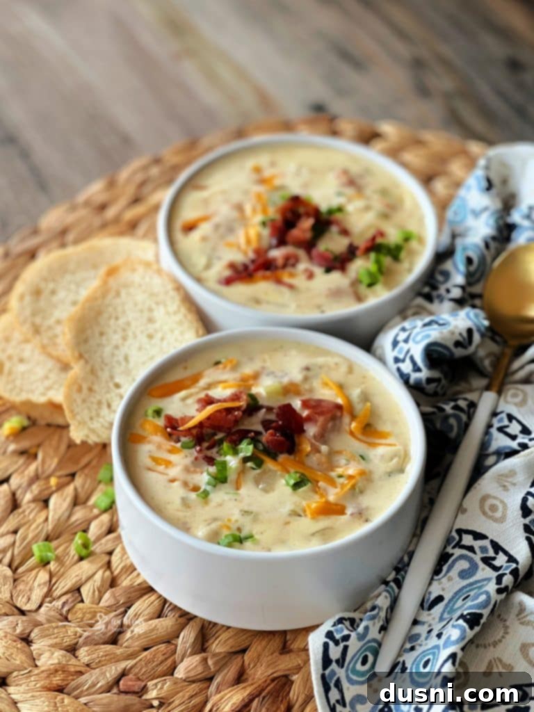 Rich and Velvety Bacon Soup 10 Creamy Bacon Soup in a bowl with green onions and crusty bread.