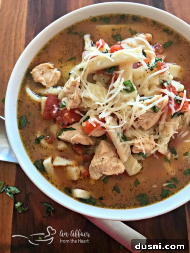 Hearty Italian Chicken Noodle Soup 9 Finished Italian Chicken Noodle Soup in a large pot, with cooked egg noodles and fresh basil stirred in, ready to be served.