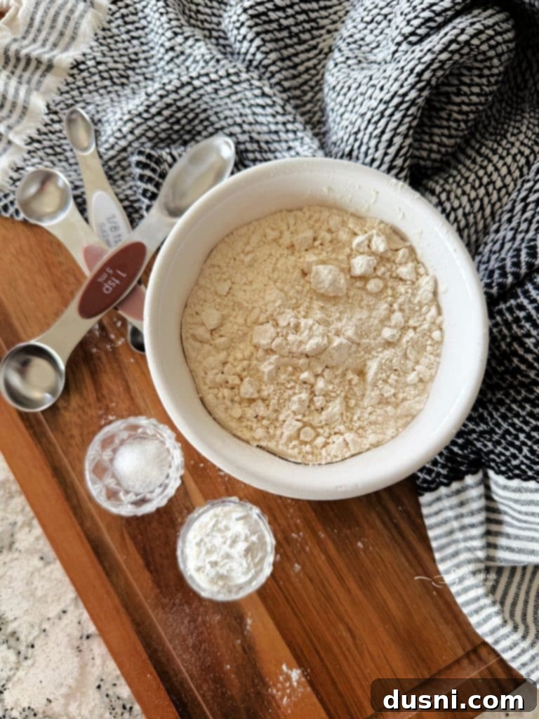 A bowl of homemade self-rising flour with a scoop inside, ready for use in baking recipes.