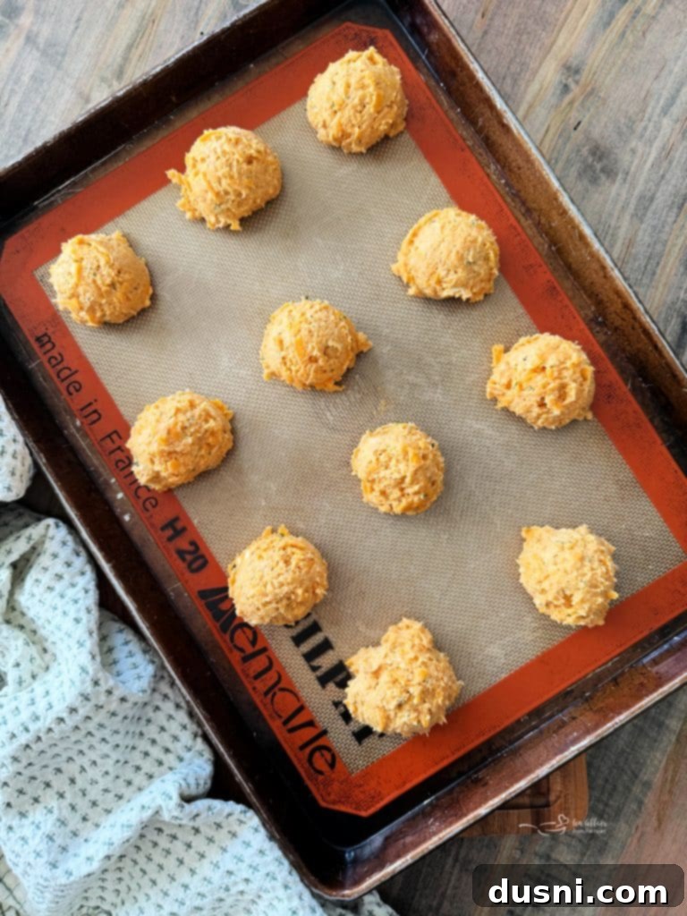 Dorothys Golden Cornbread Drops 7 Wet and dry ingredients combined with shredded cheddar cheese in a bowl, showing the dough's consistency.