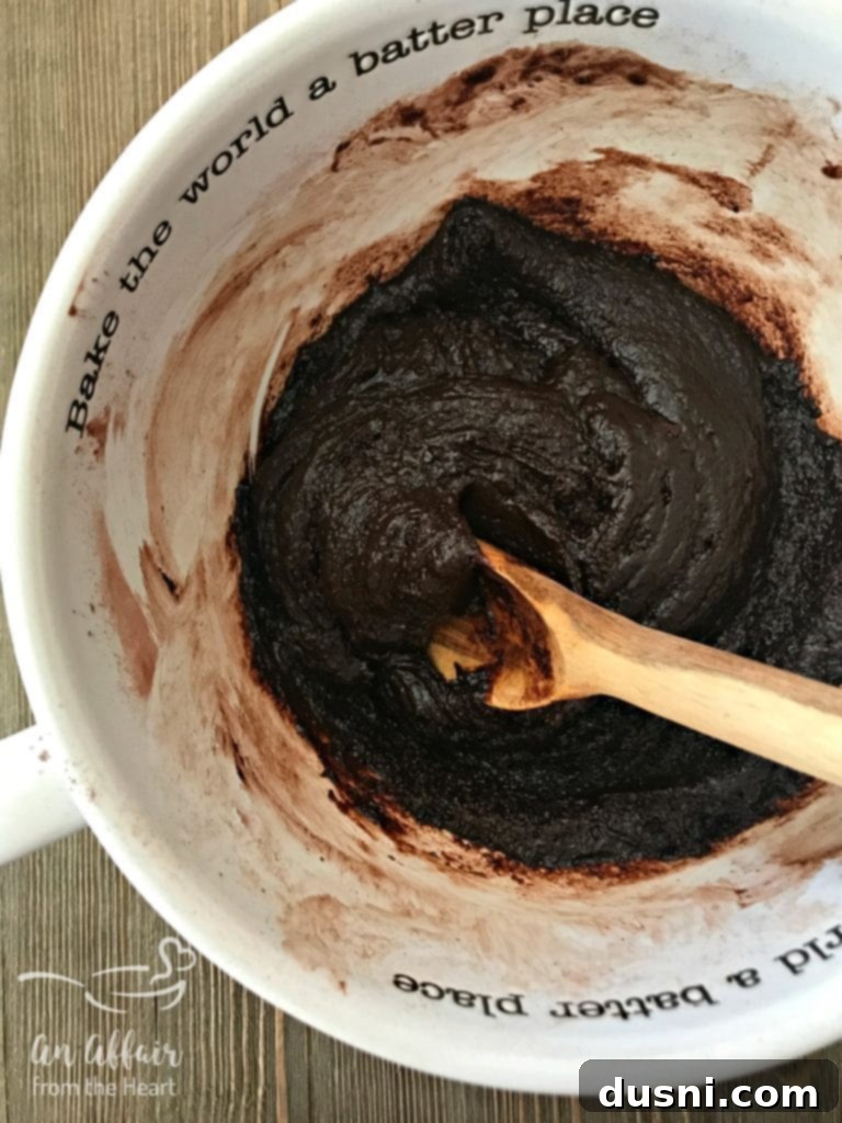 Wet ingredients being added to dry ingredients for brownies