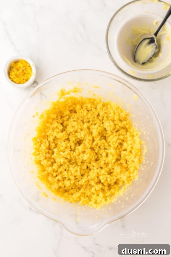 Close-up of lemon cake and frosting being mixed together with an electric whisk.