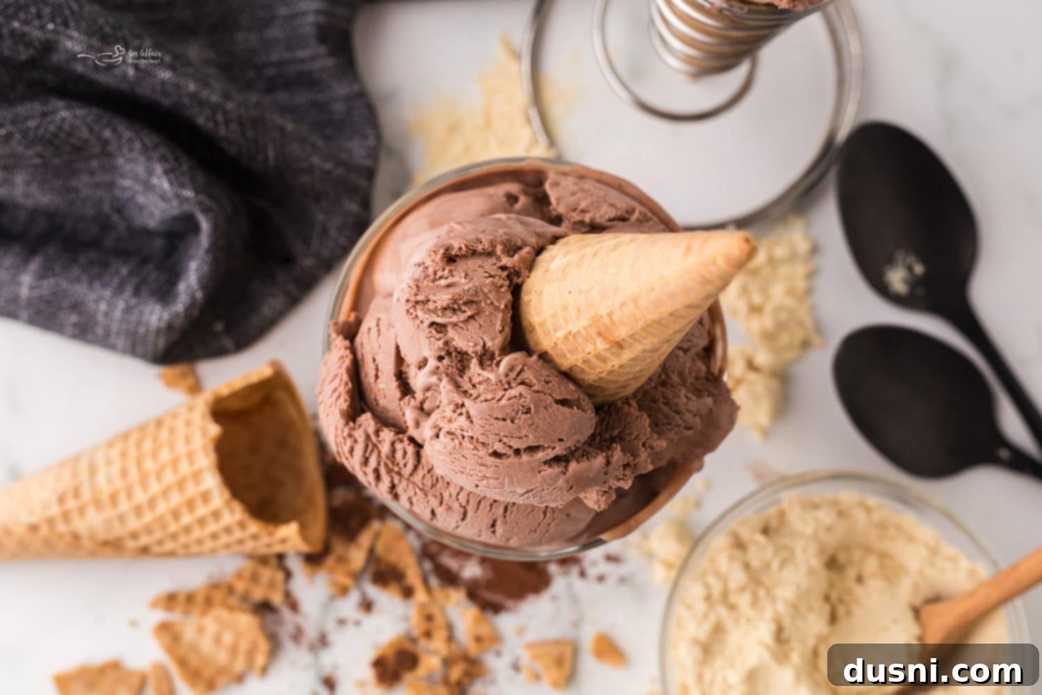 Close-up of creamy chocolate malt ice cream in a bowl with a spoon.