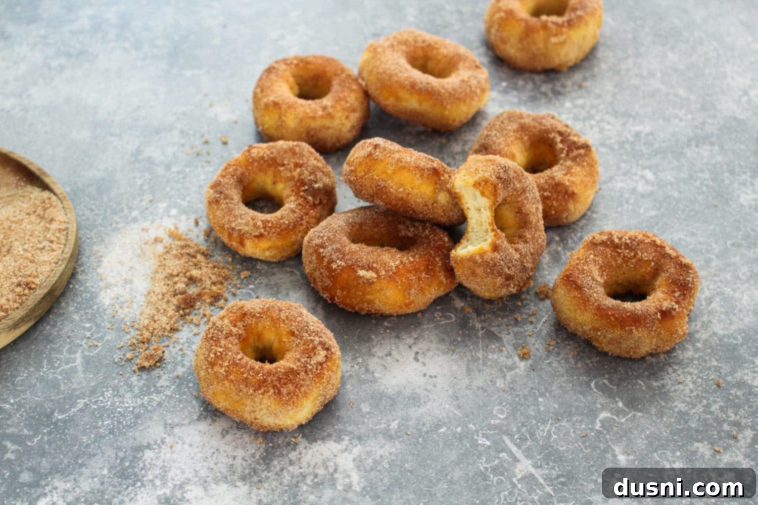 Golden Air Fryer Biscuit Doughnuts 6 Ingredients for air fryer biscuit donuts laid out: canned biscuits, butter, sugar, cinnamon.