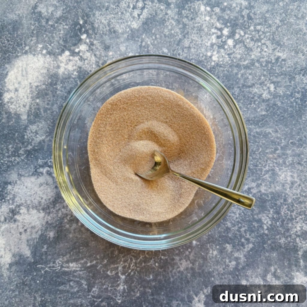 Golden Air Fryer Biscuit Doughnuts 7 A small bowl of cinnamon sugar mixture.