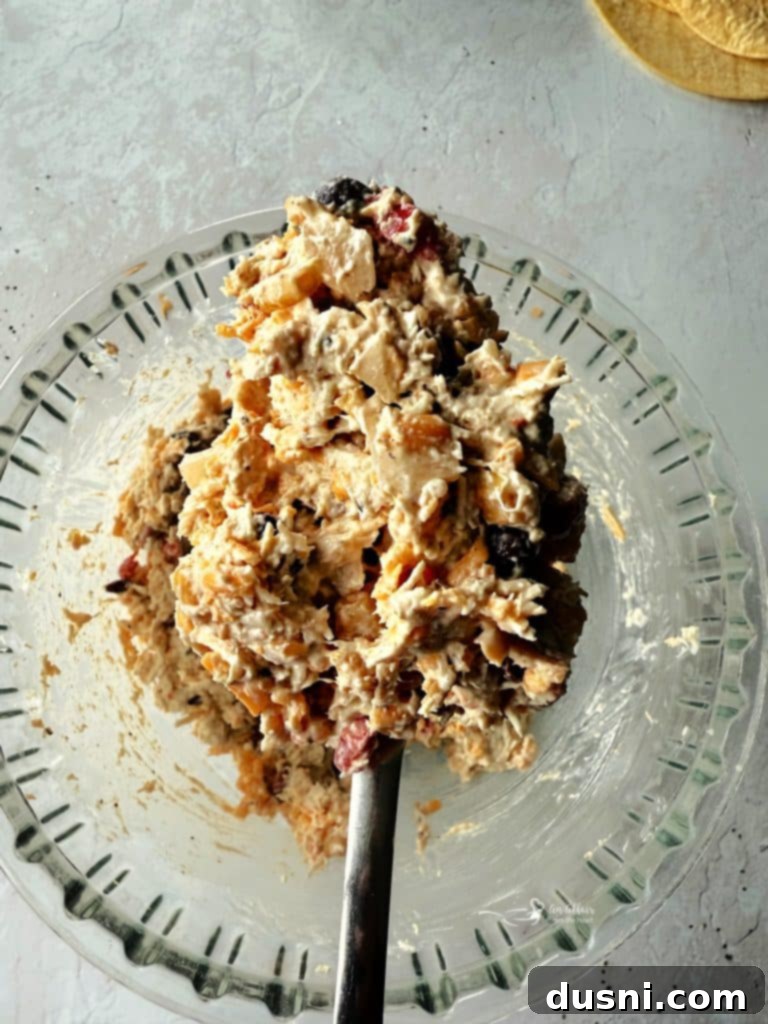 Bowl of creamy filling ingredients for taquitos, showing shredded chicken, cheese, and Cowboy Caviar mixed together.