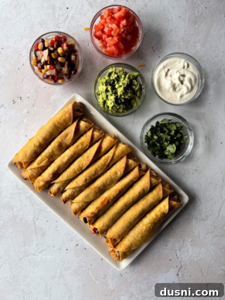 Baked Chicken and Cowboy Caviar Taquitos freshly removed from the oven, showing their golden and crispy texture.