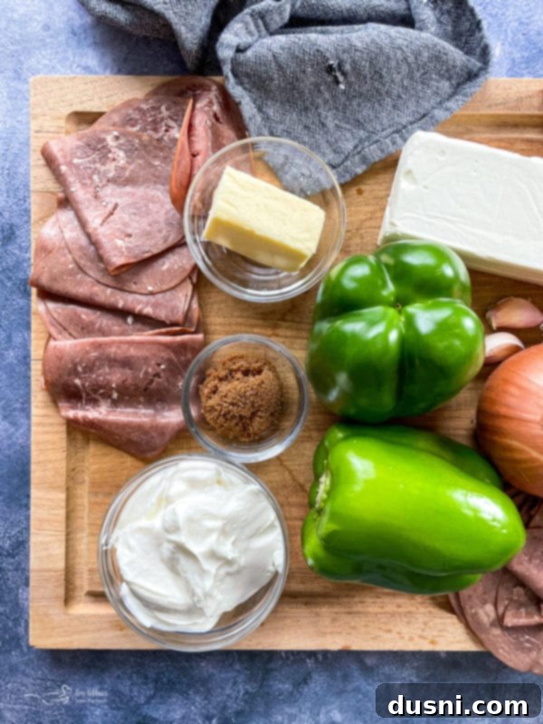 roast beef, peppers, cream cheese, provolone, butter, brown sugar, onions, garlic on cutting board