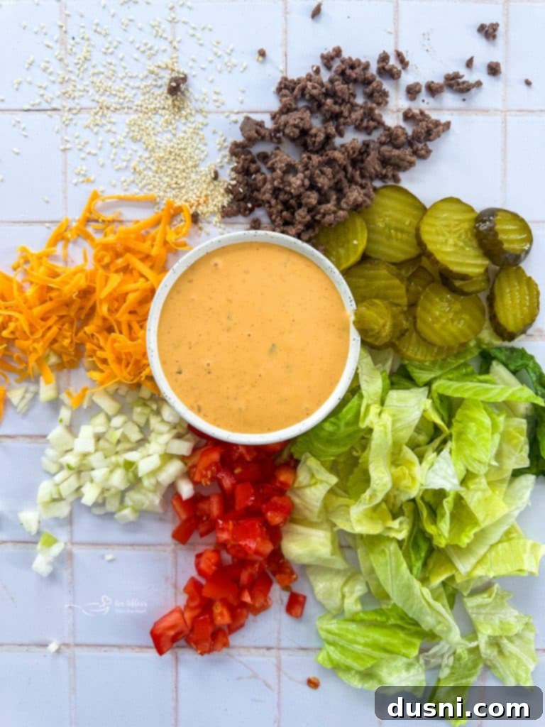 Big Mac Salad with dressing drizzled on top, garnished with sesame seeds.