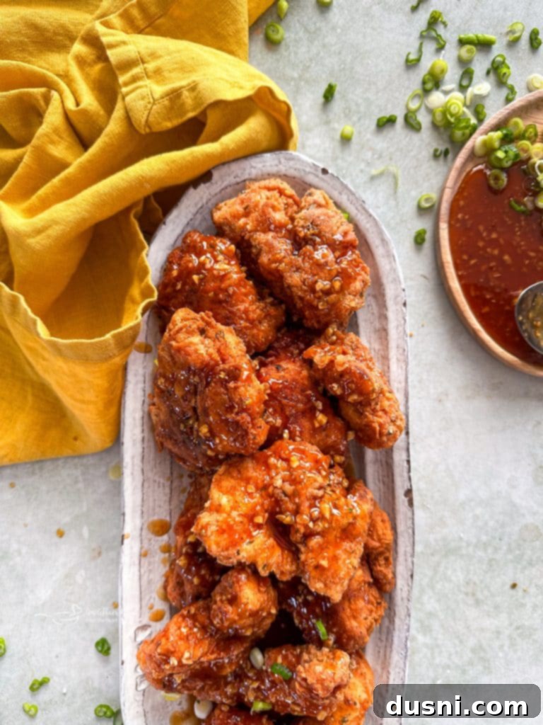Hot Honey Glazed Crispy Popcorn Chicken 11 Close up of crispy Honey chicken on a white serving platter.