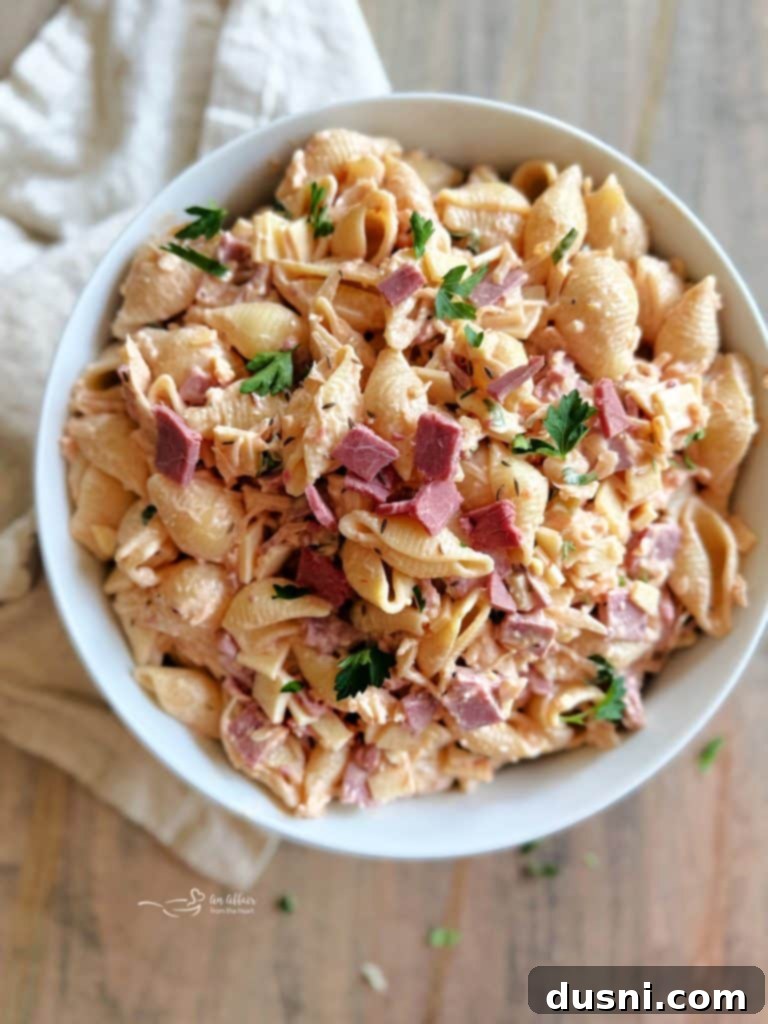 Reuben Pasta Salad in a white bowl, ready to be served, with a fork.