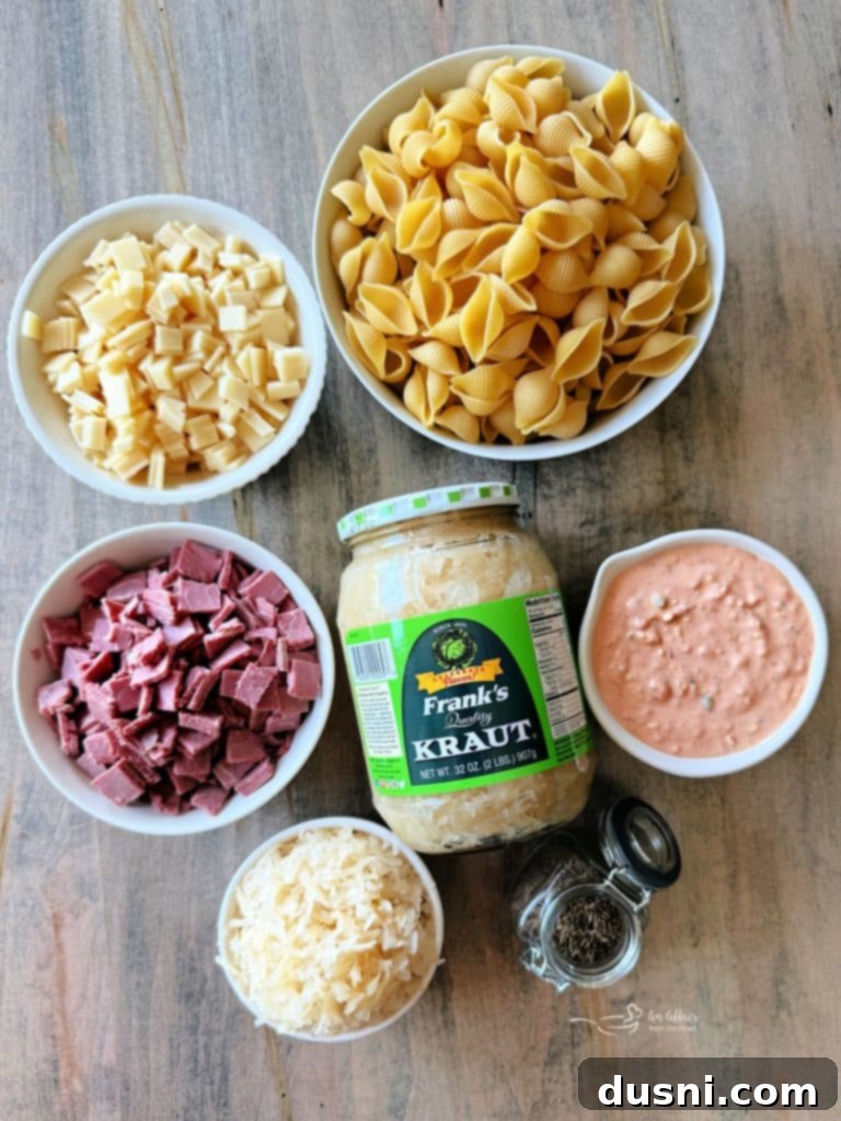 Reuben Pasta Salad being mixed in a large white bowl with a serving spoon.