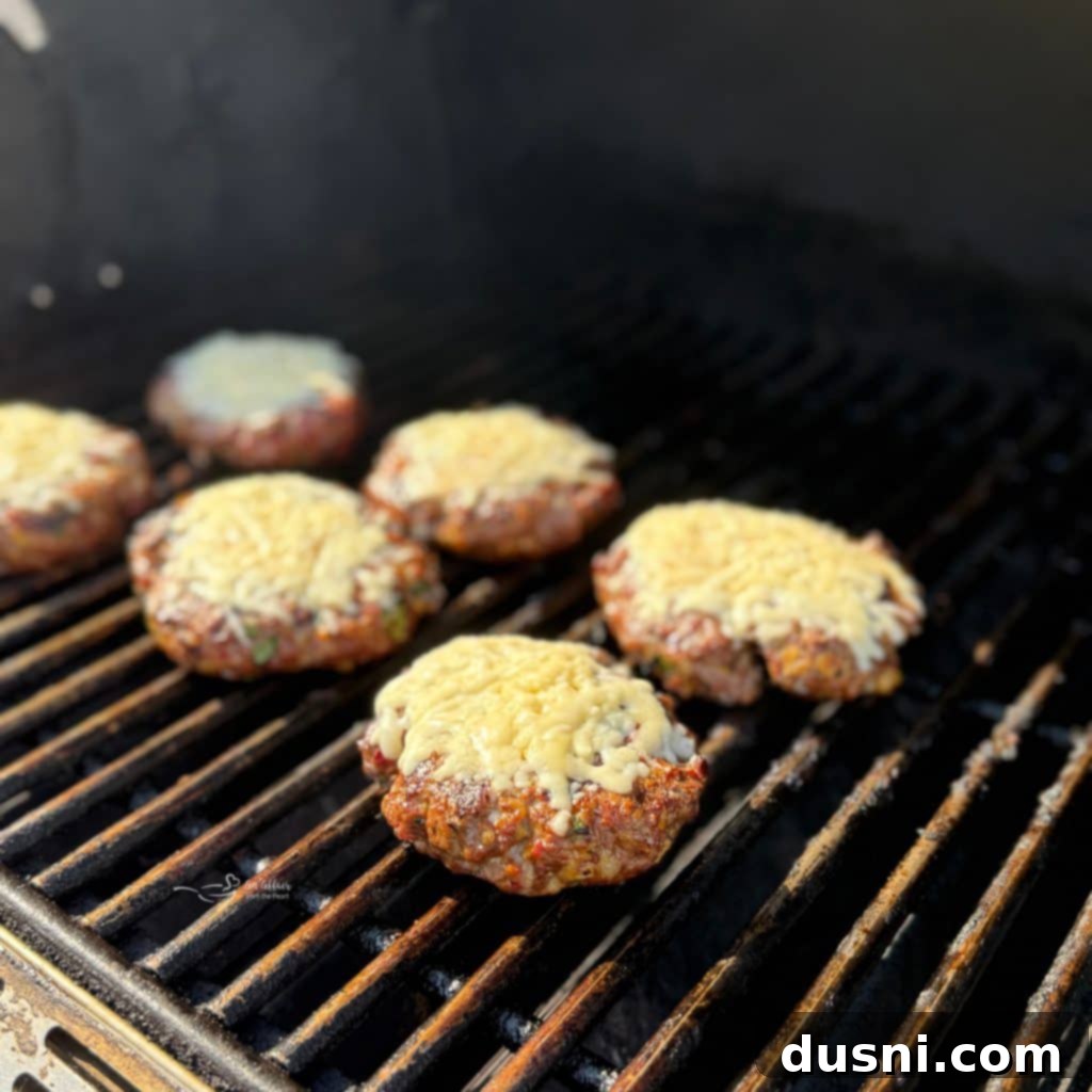 Mexican Street Burgers 13 Mexican hamburgers grilling with melted cheese on top.