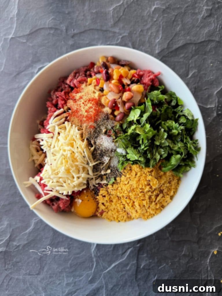 Mexican Street Burgers 9 Mixing ground beef with spices and other ingredients in a bowl.