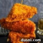 Crispy Cheesy French Toast 15 Three Cheese Frenchees stacked on a dark colored plate.