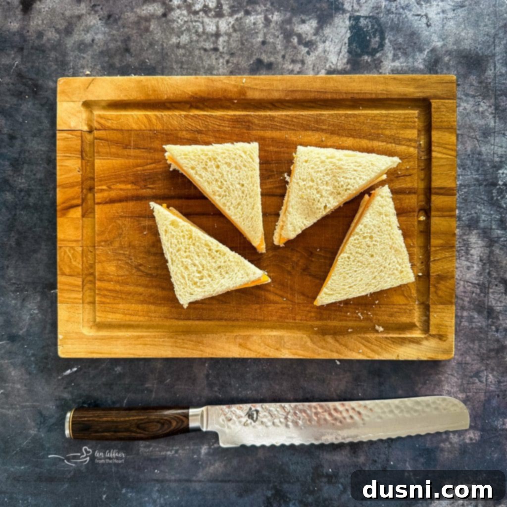 Crispy Cheesy French Toast 8 Cutting the crusts off a cheese sandwich and then slicing into triangles.