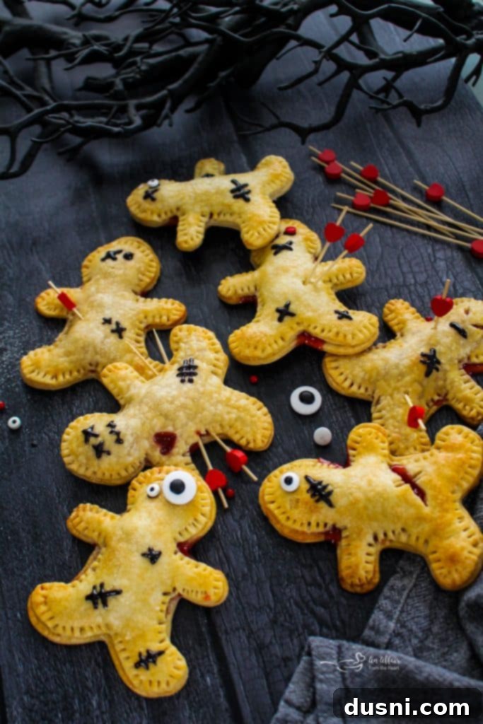 Mystic Doll Pastries 5 A Voodoo Doll Hand Pie with black icing stitches, candy eyes, and a toothpick, on a white plate ready to be served.