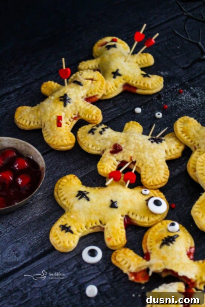 Mystic Doll Pastries 7 A batch of Voodoo Doll Hand Pies on a baking sheet, freshly baked and golden brown before final decorations.