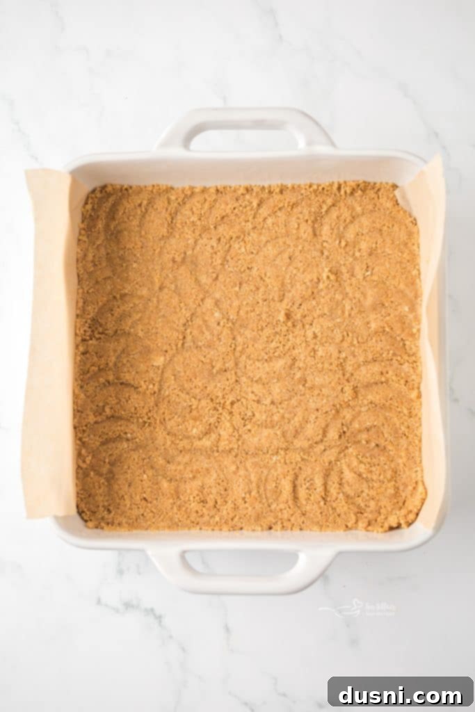 Zesty Key Lime Pie Bars 8 Pressing graham cracker crust into an 8x8 inch baking pan.